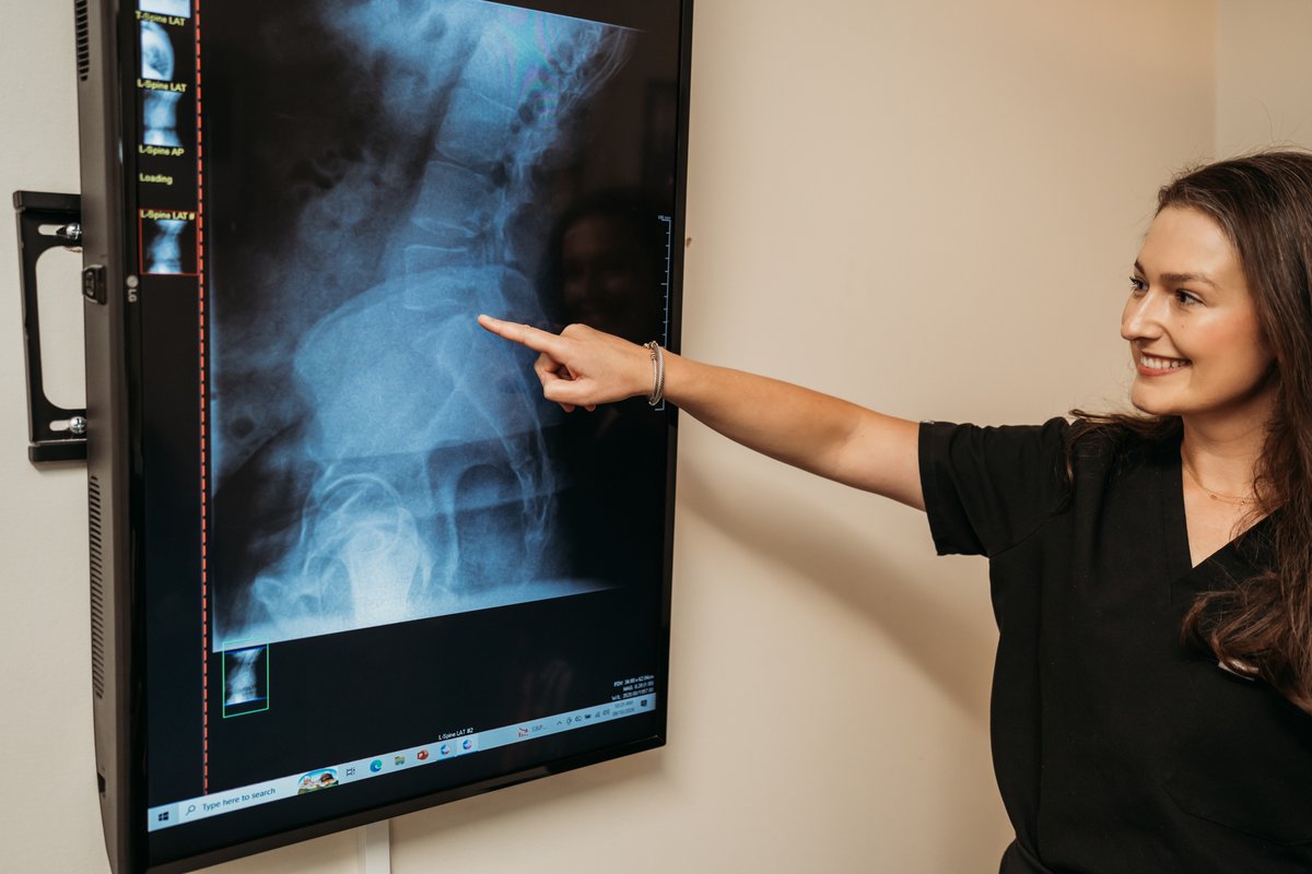 Dr. Lauren evaluating digital spinal X-rays on a large HD monitor