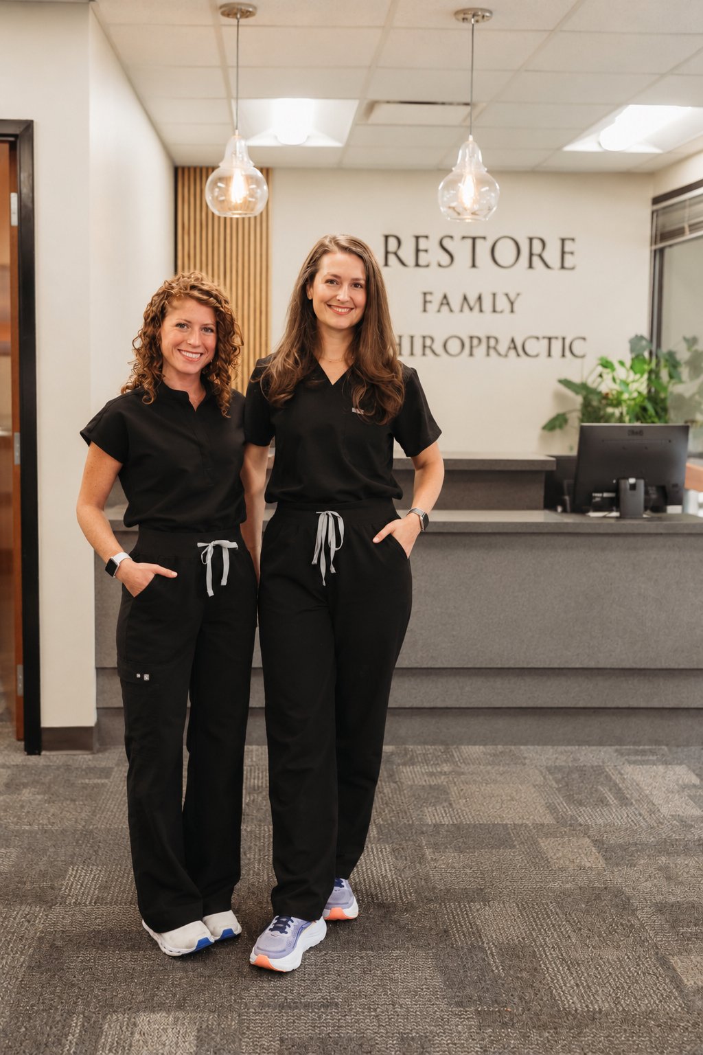 Dr. Lauren Rissman and Dr. Morgan Jones at the Restore Family Chiropractic front desk