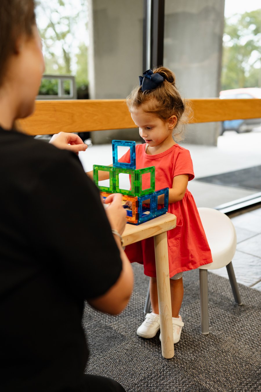 Child happily playing with magnetic tiles in pediatric care area